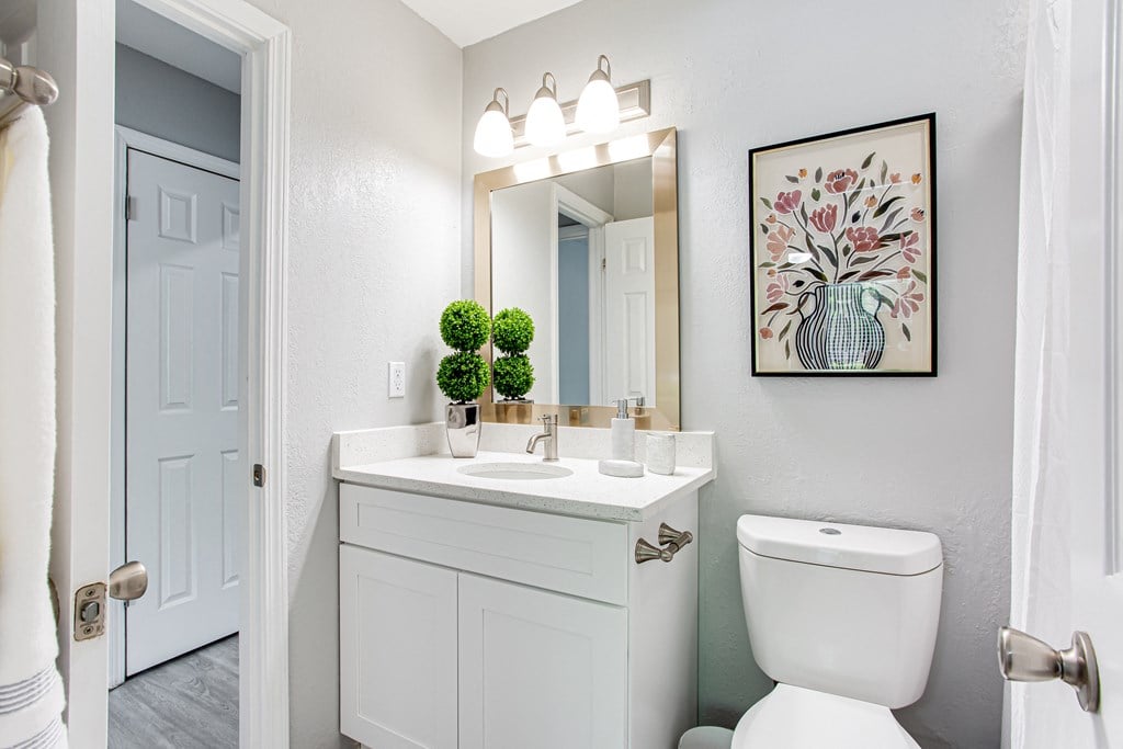 a bathroom with a toilet sink and a mirror at Parc at 1875, College Park, GA
