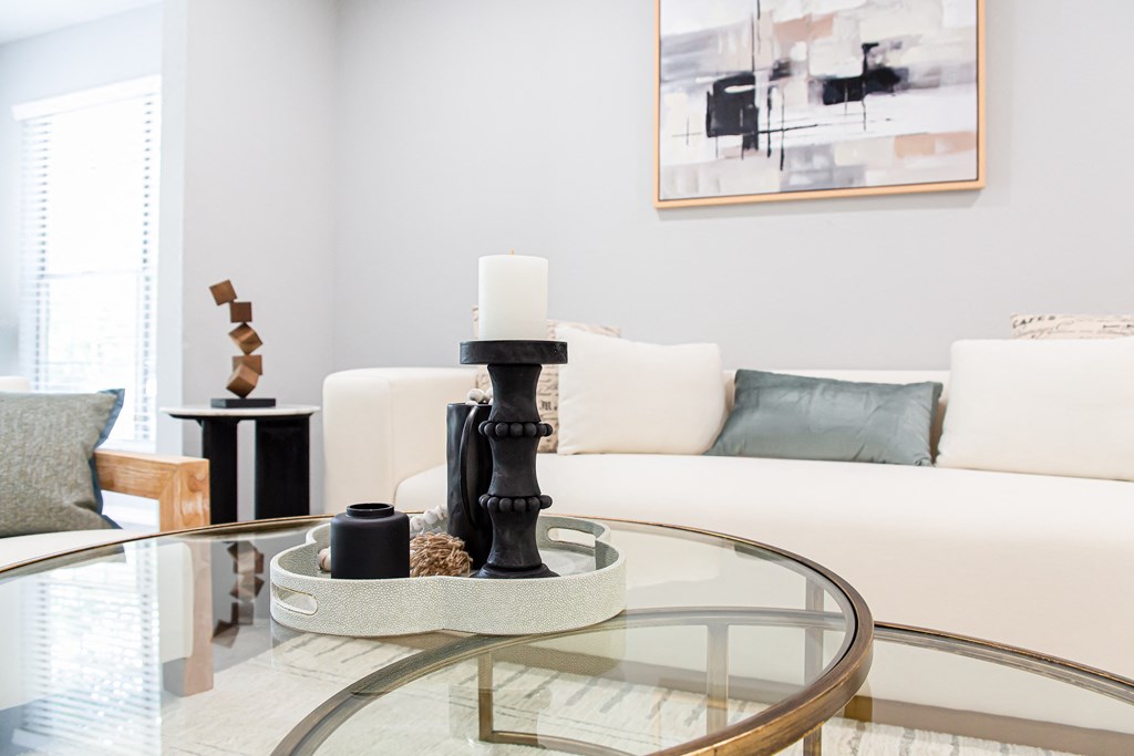 a living room with white couches and a glass coffee table at Parc at 1875, College Park