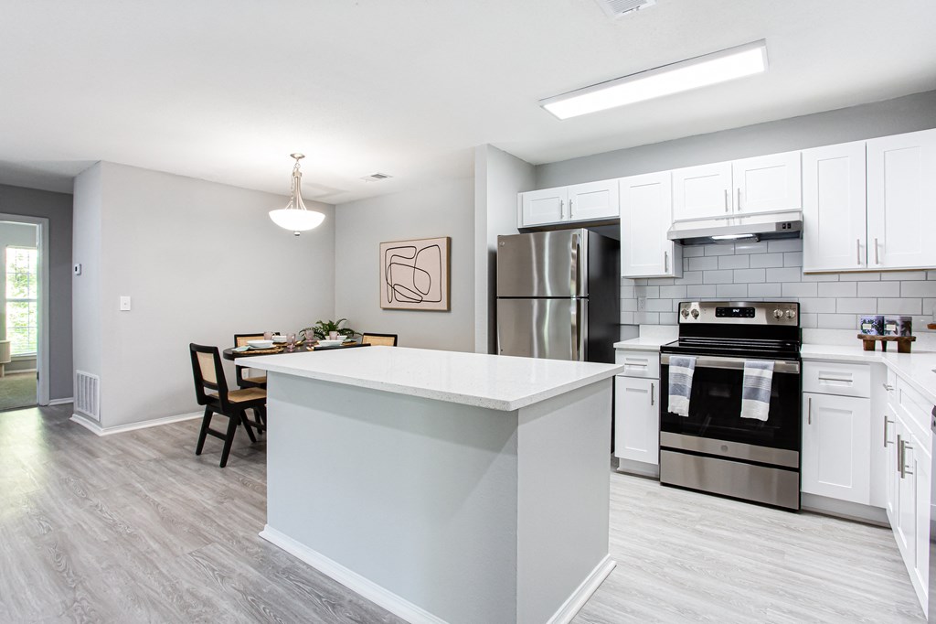 an open kitchen with a large island and stainless steel appliances at Parc at 1875, College Park, GA