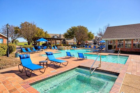 A pool area with blue chairs and a small pool.