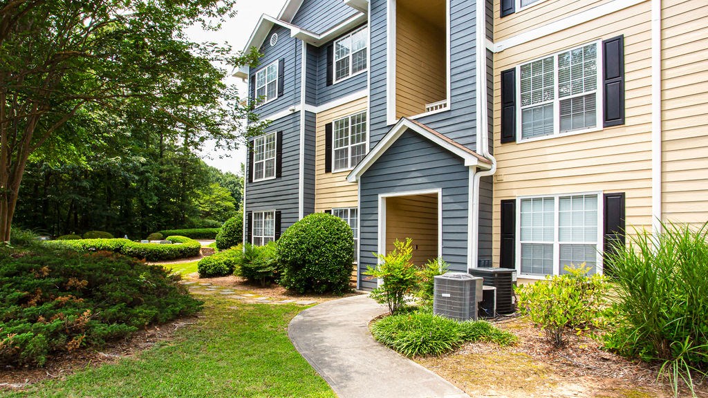 a blue and yellow house with a walkway leading to the front door