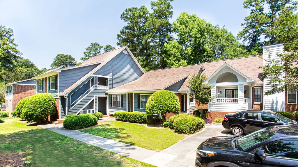a row of houses with cars parked in front of them