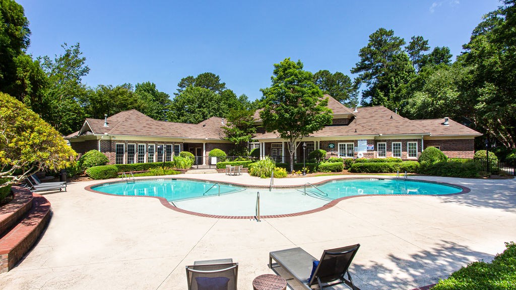 a swimming pool with a house in the background