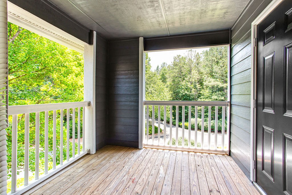 a balcony with a door and a view of a wooded area