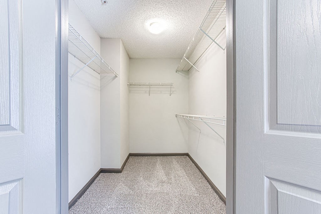 a walk in closet with white walls and a white ceiling