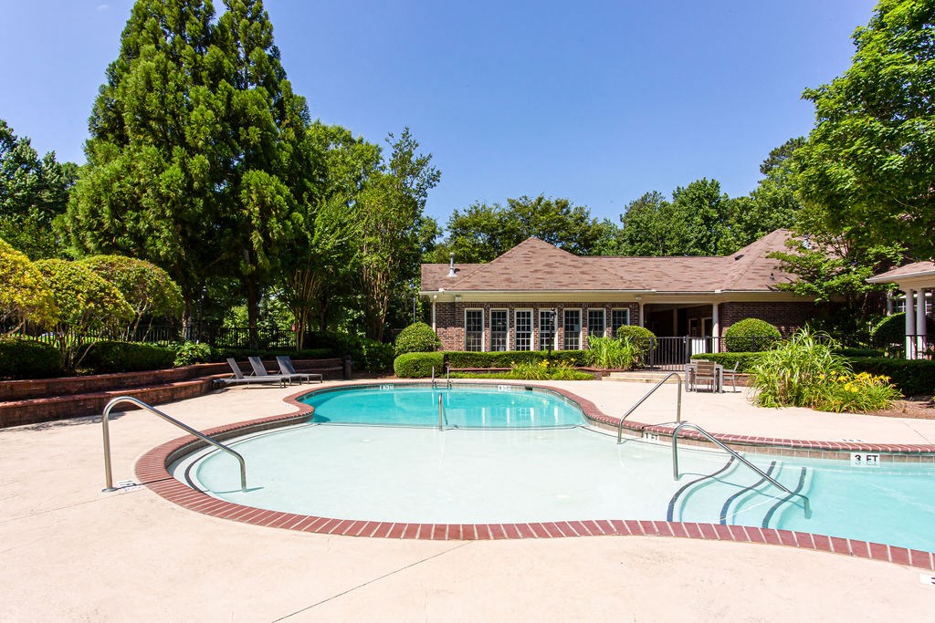 a swimming pool with a house in the background