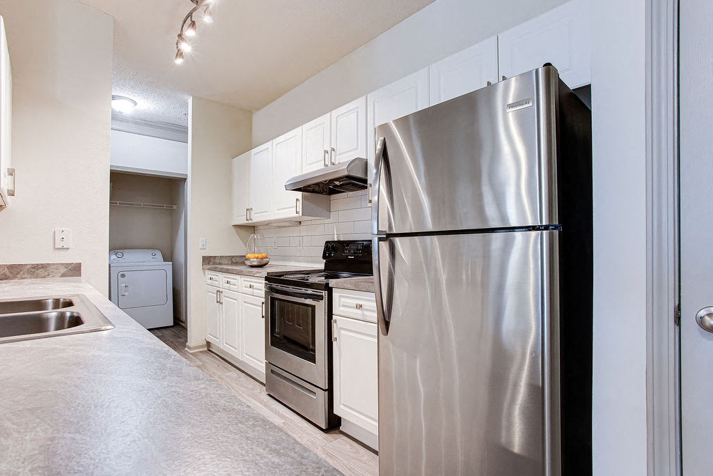 a kitchen with white cabinets and stainless steel appliances