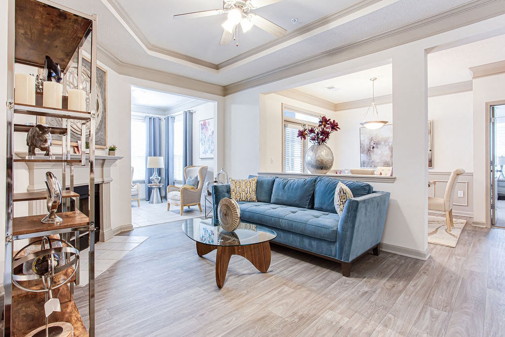 a living room filled with furniture and a ceiling fan