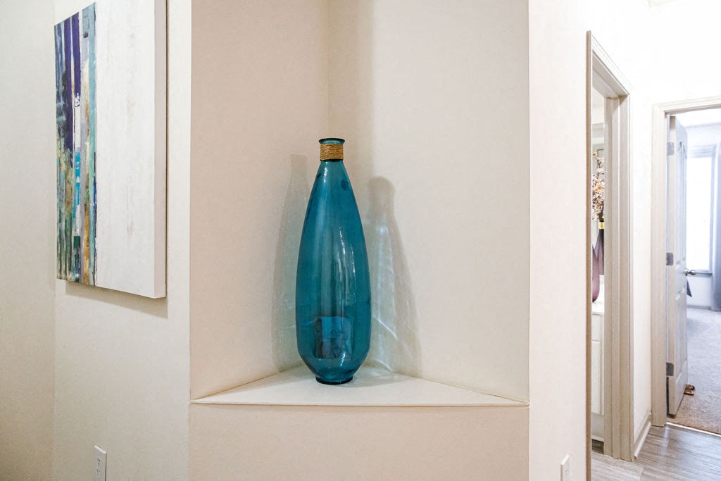 a blue vase sitting on top of a white shelf