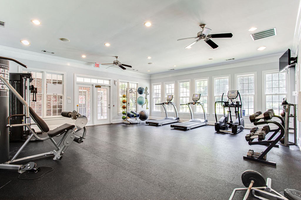 a home gym with exercise equipment and windows