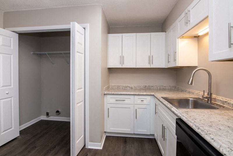 Kitchen with cabinets and store room at The Cleo Apartments, Alabama