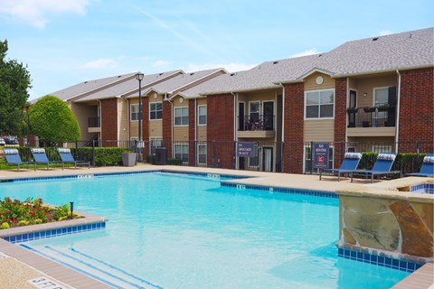 A swimming pool in front of apartment buildings.