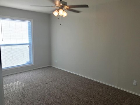 a bedroom with a ceiling fan and a window