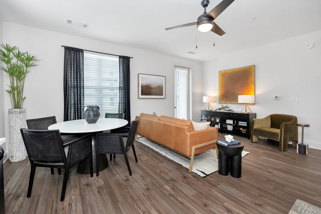 A living room with a brown floor and white walls.