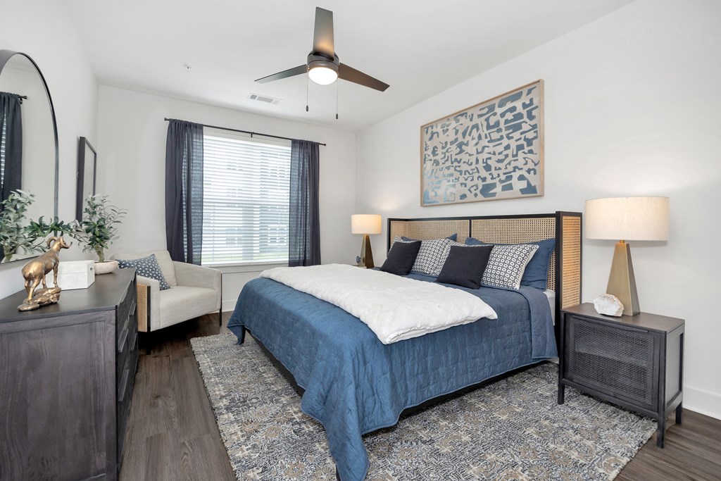 A bedroom with a bed, nightstand, and a ceiling fan.