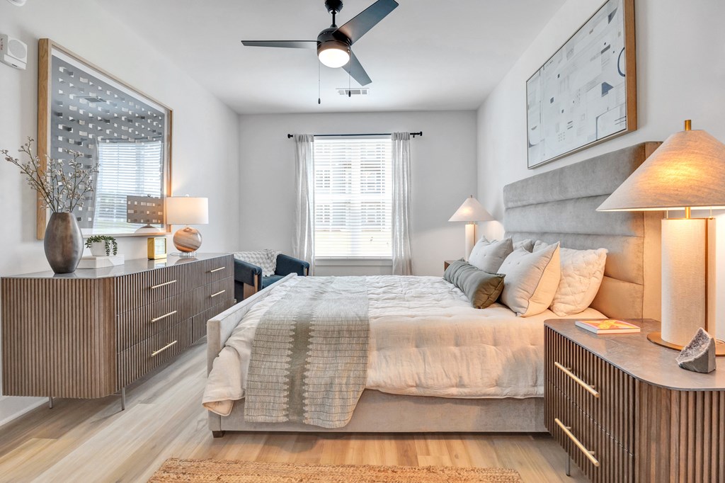A bedroom with a bed, nightstands, and a ceiling fan.