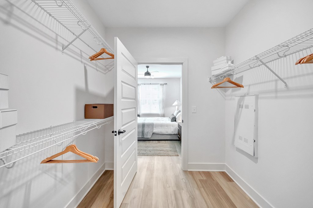 A hallway with a white wall and a white door.