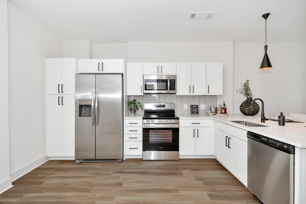 A modern kitchen with stainless steel appliances and white cabinets.
