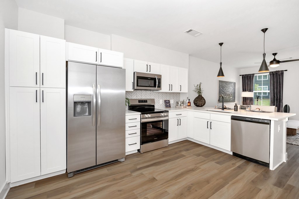 A modern kitchen with stainless steel appliances and white cabinets.