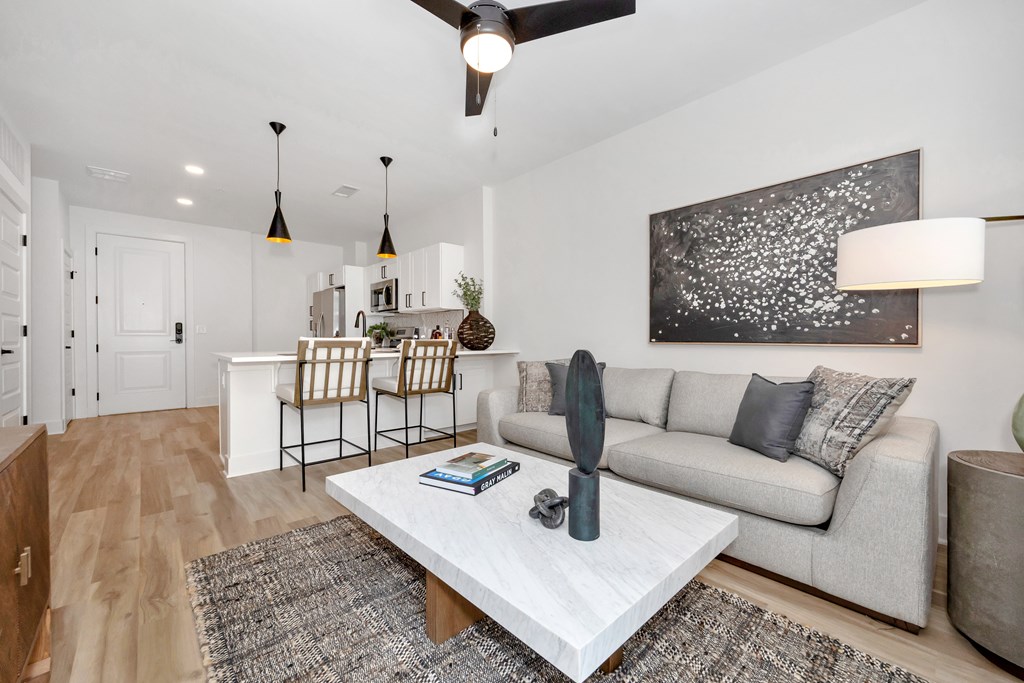 A modern living room with a white coffee table and a grey couch.