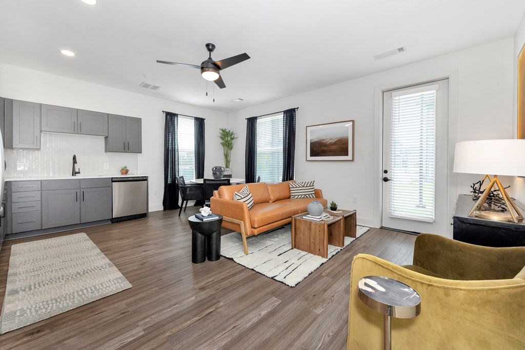 A living room with a yellow couch and a ceiling fan.