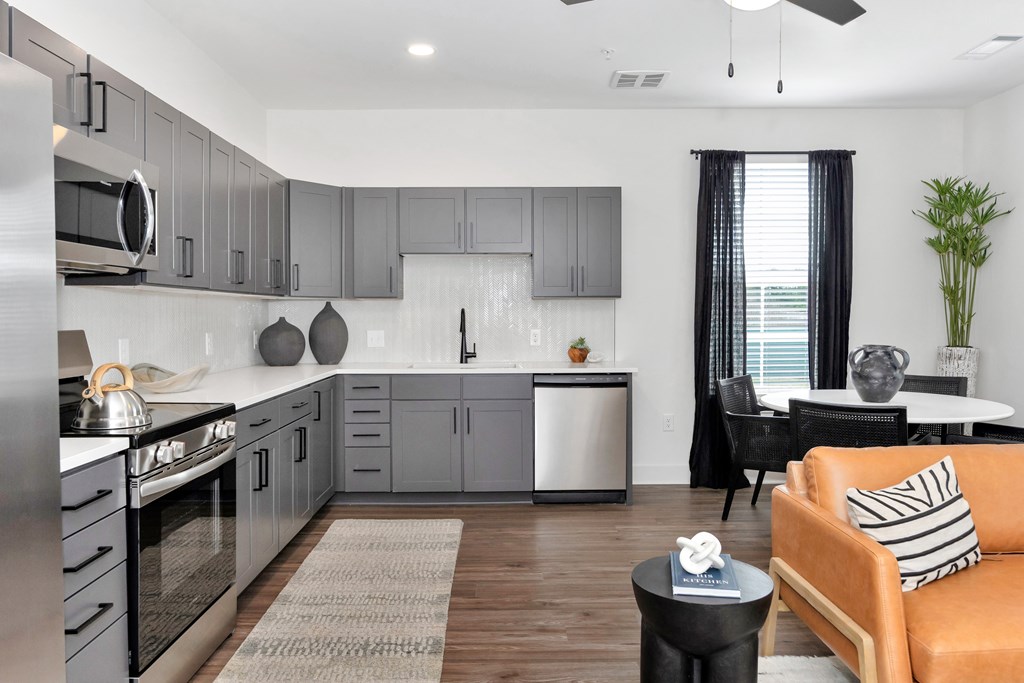 A modern kitchen with a dining area and a couch.