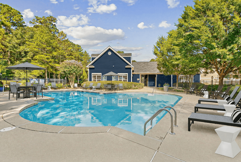 A swimming pool with a black umbrella and a bench.
