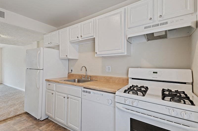 Kitchen with white cabinets and white appliances at Barracks West apartments in Charlottesville, VA
