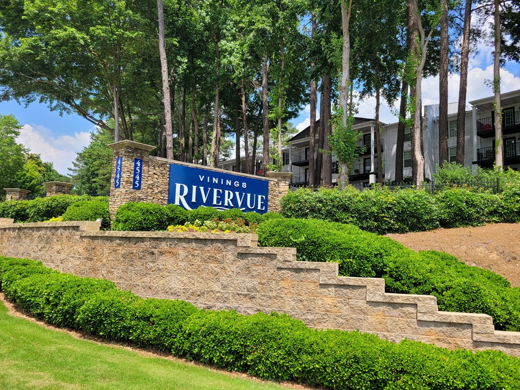 a brick retaining wall with a blue sign that says winnipeg riviera at Vinings RiverVue Apartments, Atlanta, Georgia