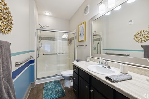 A bathroom with a sink, mirror, and shower.