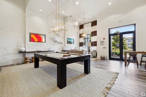 A room with a pool table and a painting on the wall.