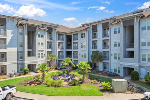 A large apartment complex with a courtyard and palm trees.