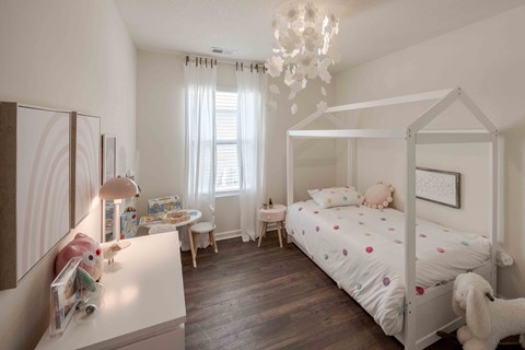 a bedroom with a bed and a desk and a chandelier