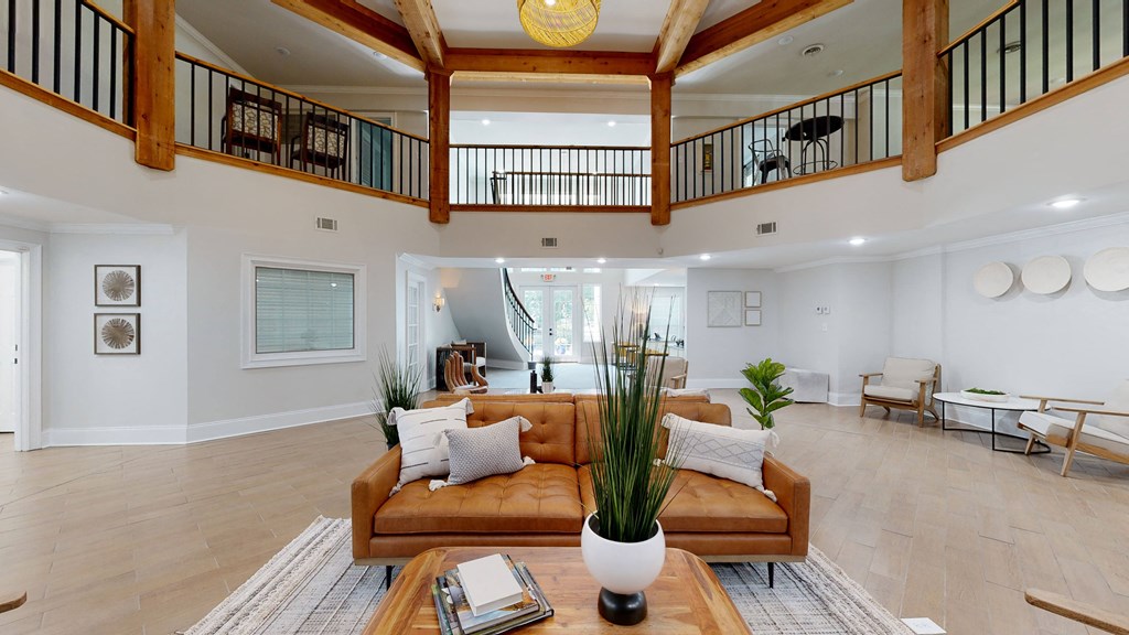 a living room with white walls and a wooden ceiling with exposed beams at Vinings RiverVue Apartments, Atlanta