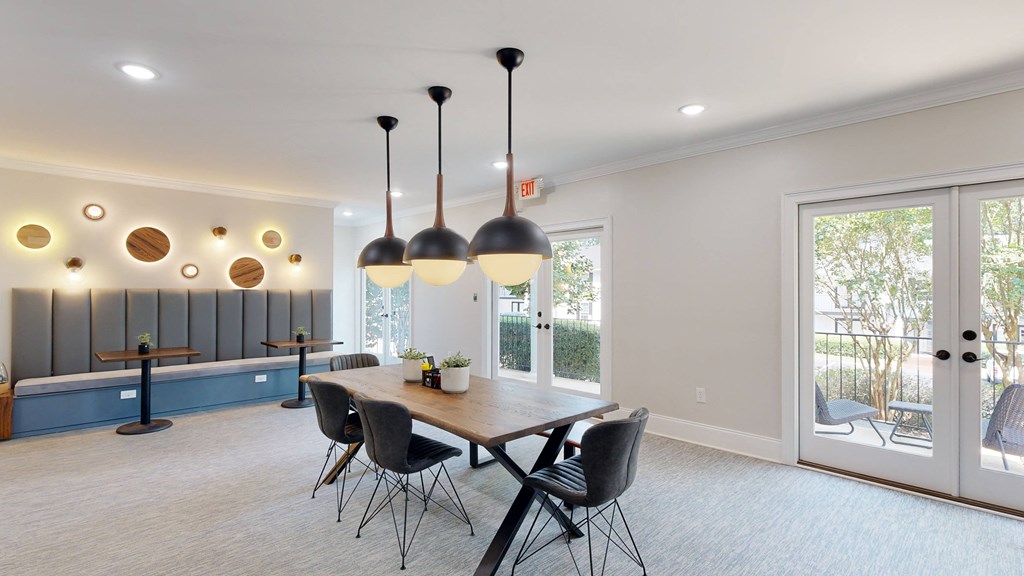 a dining area with a wooden table and black chairs at Vinings RiverVue Apartments, Atlanta, Georgia