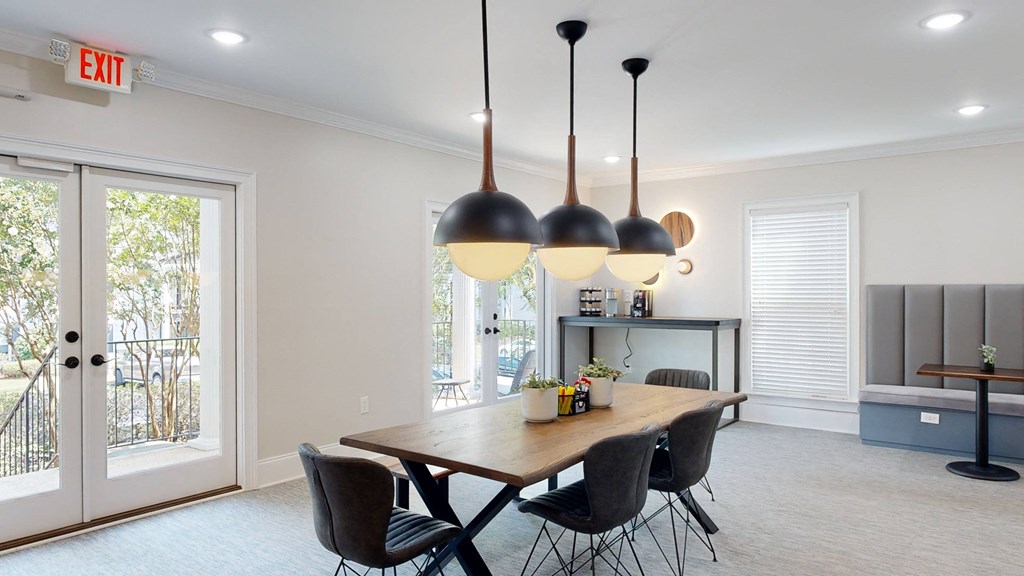 a dining area with a wooden table and black and white chairs at Vinings RiverVue Apartments, Georgia, 30339