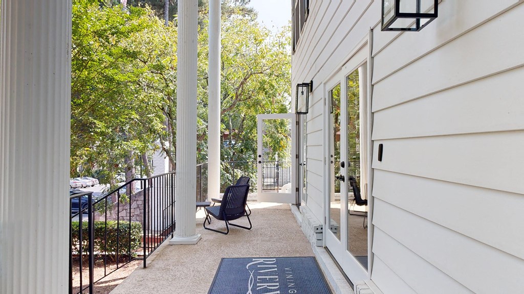 a patio with a chair and a rug in front of a house at Vinings RiverVue Apartments, Georgia