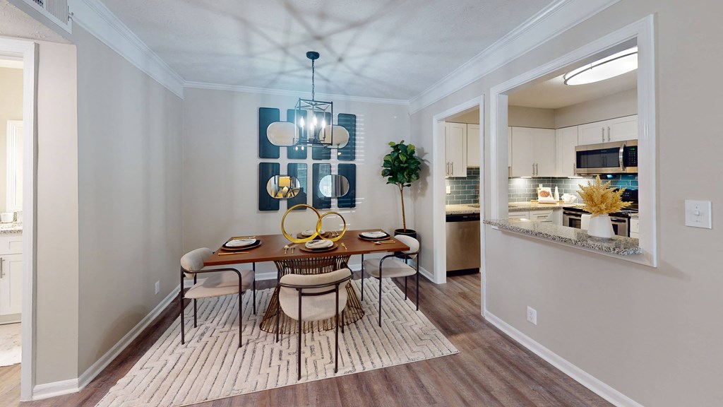 a dining room with a table and chairs and a kitchen in the background at Vinings RiverVue Apartments, Georgia, 30339
