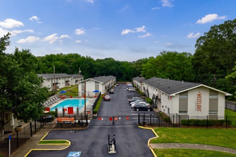 A view of a road with apartment buildings on either side and a pool in the middle.