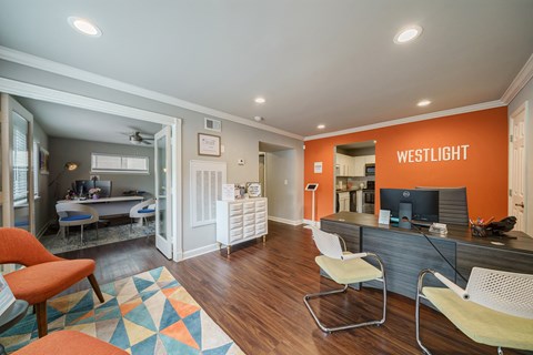 A leasing office space with a desk, chairs, and a computer.
