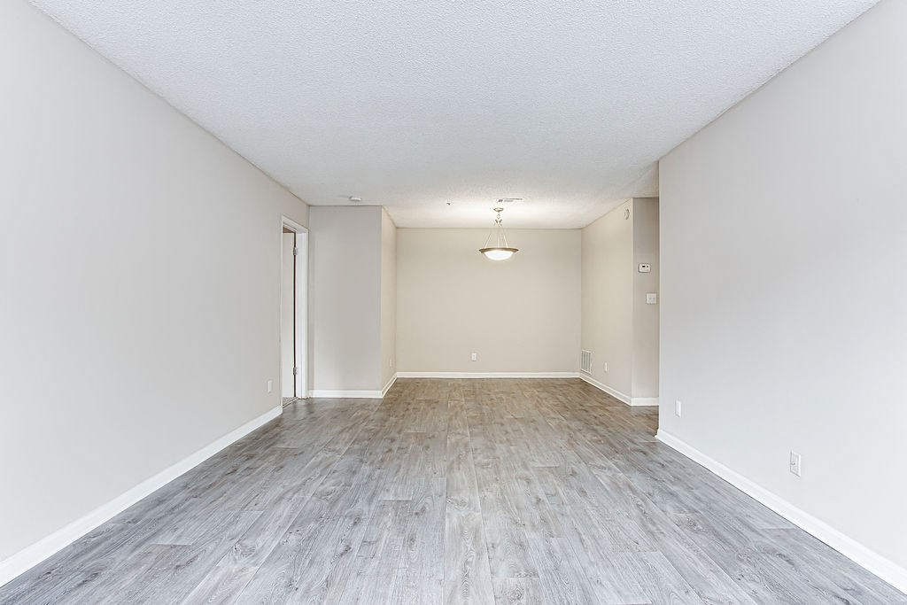 an empty living room with white walls and wood floors