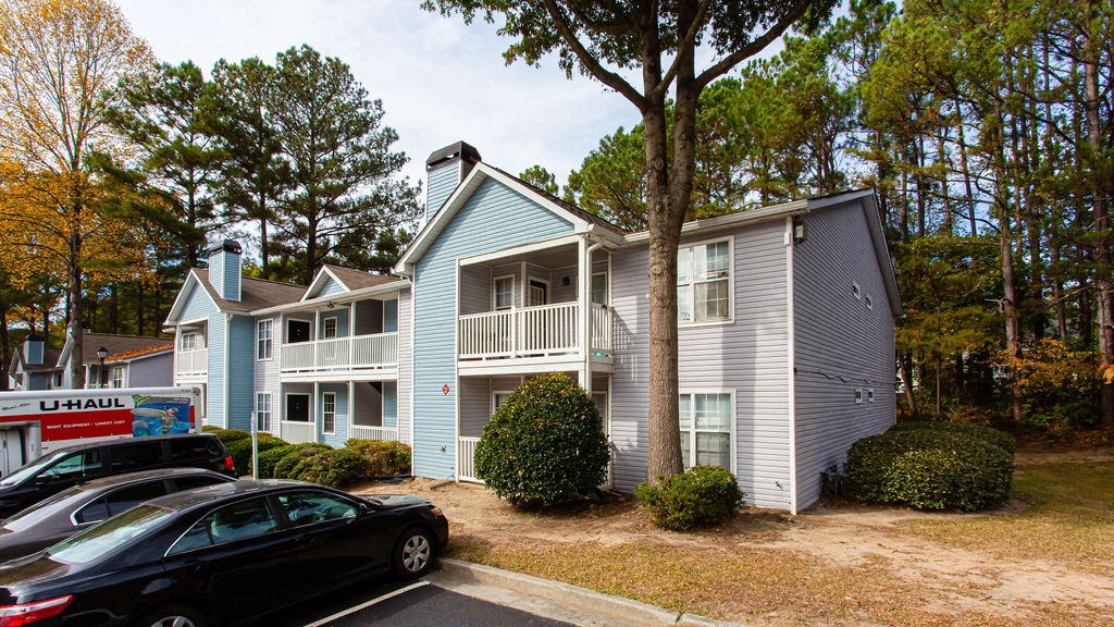 an apartment building with cars parked in front of it