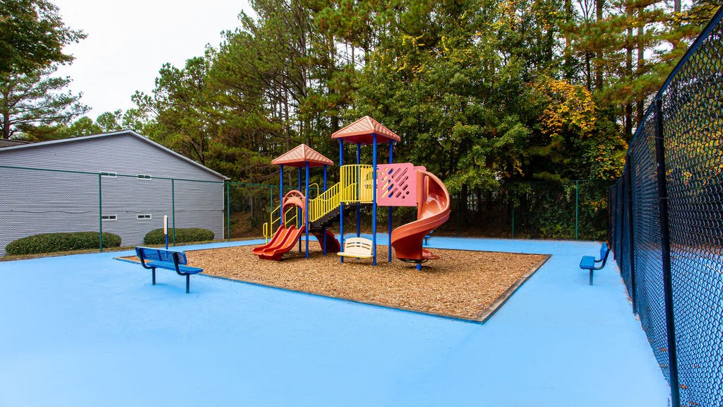 a playground on a blue surface with benches