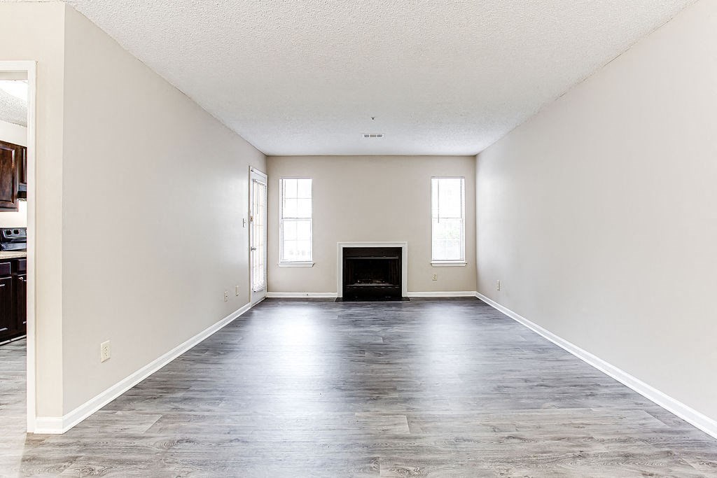 an empty living room with white walls and a fireplace