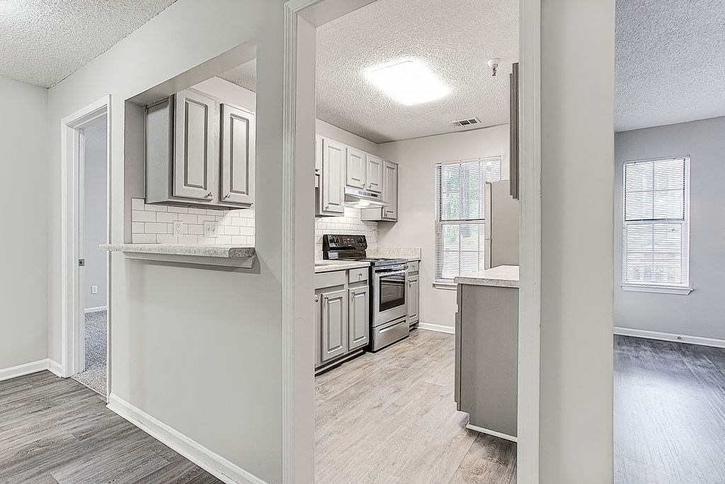 an open kitchen with white cabinets and a wood floor