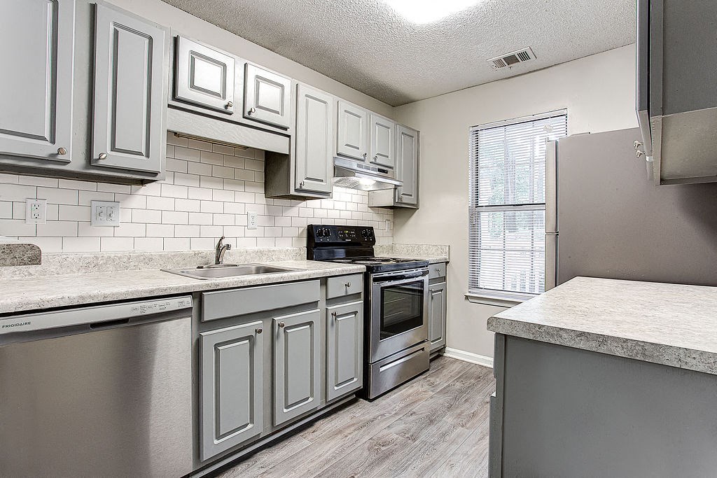 a kitchen with stainless steel appliances and white cabinets