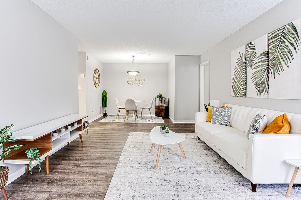 a living room with white furniture and a rug