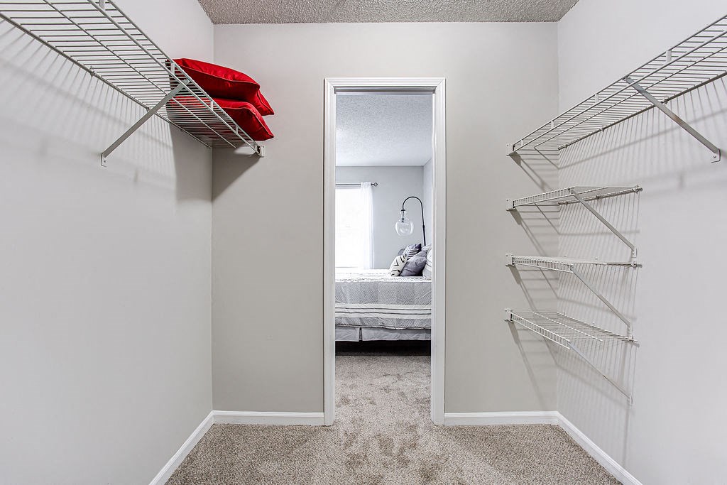 a bedroom with a closet and a mirrored door to a bedroom