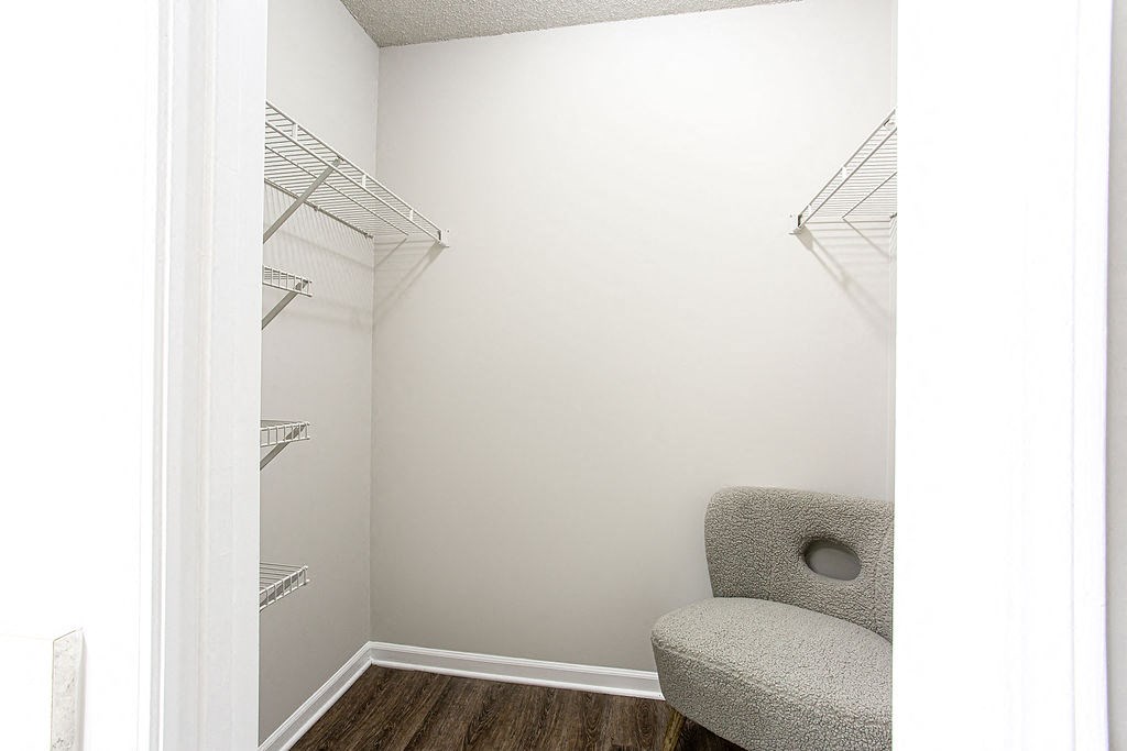 an empty room with a chair and a closet