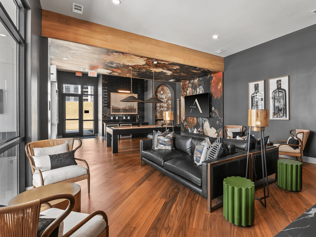 A modern living room with a black couch and wooden floors.